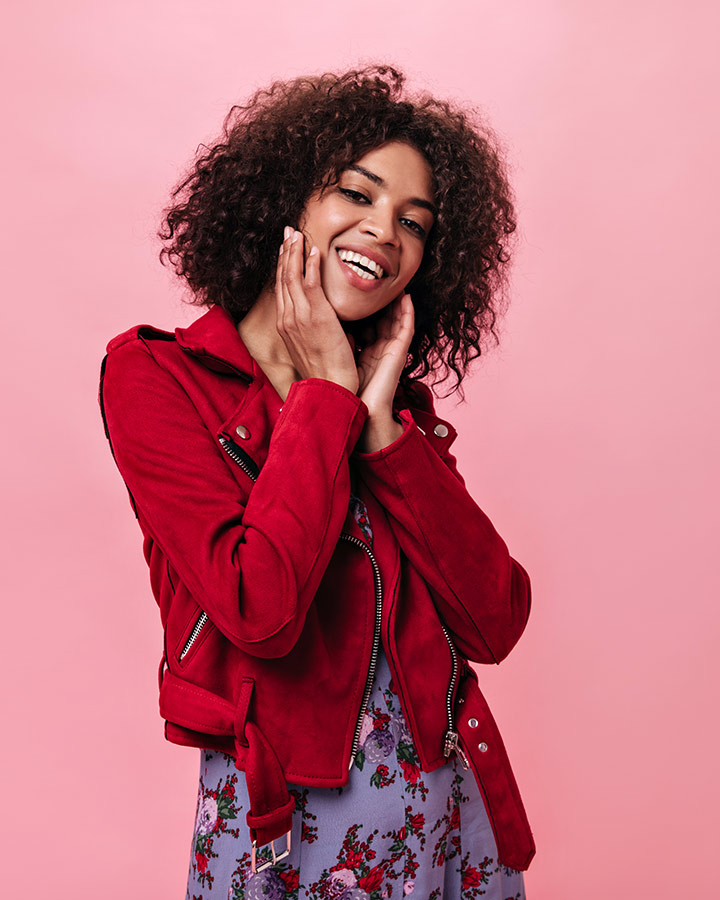 Charming girl red jacket laughs pink wall.jpg